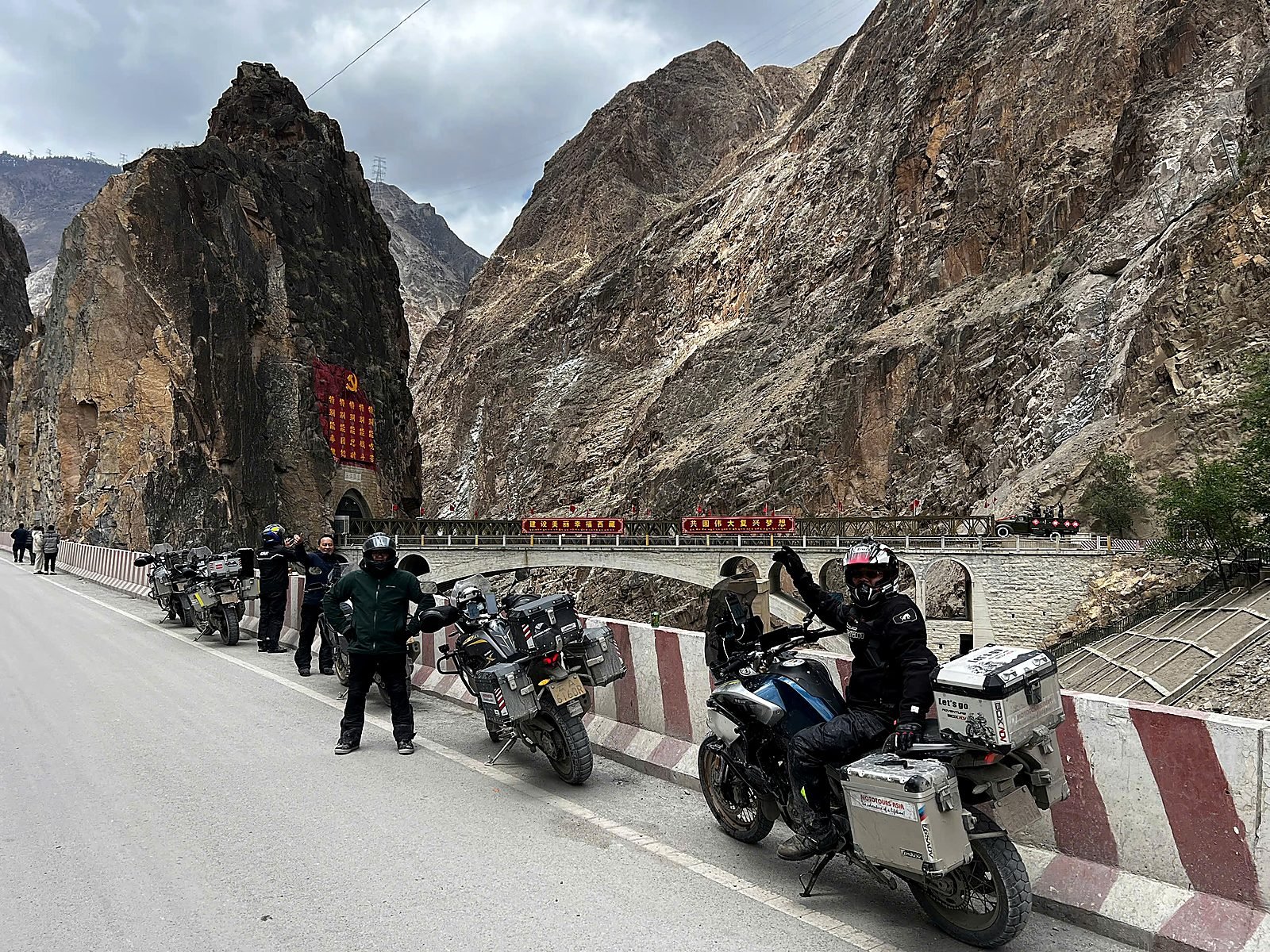 Đoàn xe mô tô MotoTours Asia dừng bên cầu đá trong hẻm núi trên quốc lộ G318