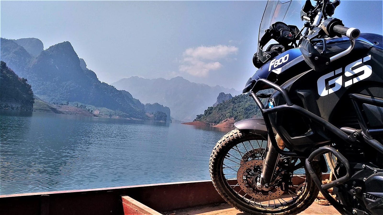 Xe mô tô BMW F800GS đứng trên thuyền gỗ vượt lòng hồ sông Đà